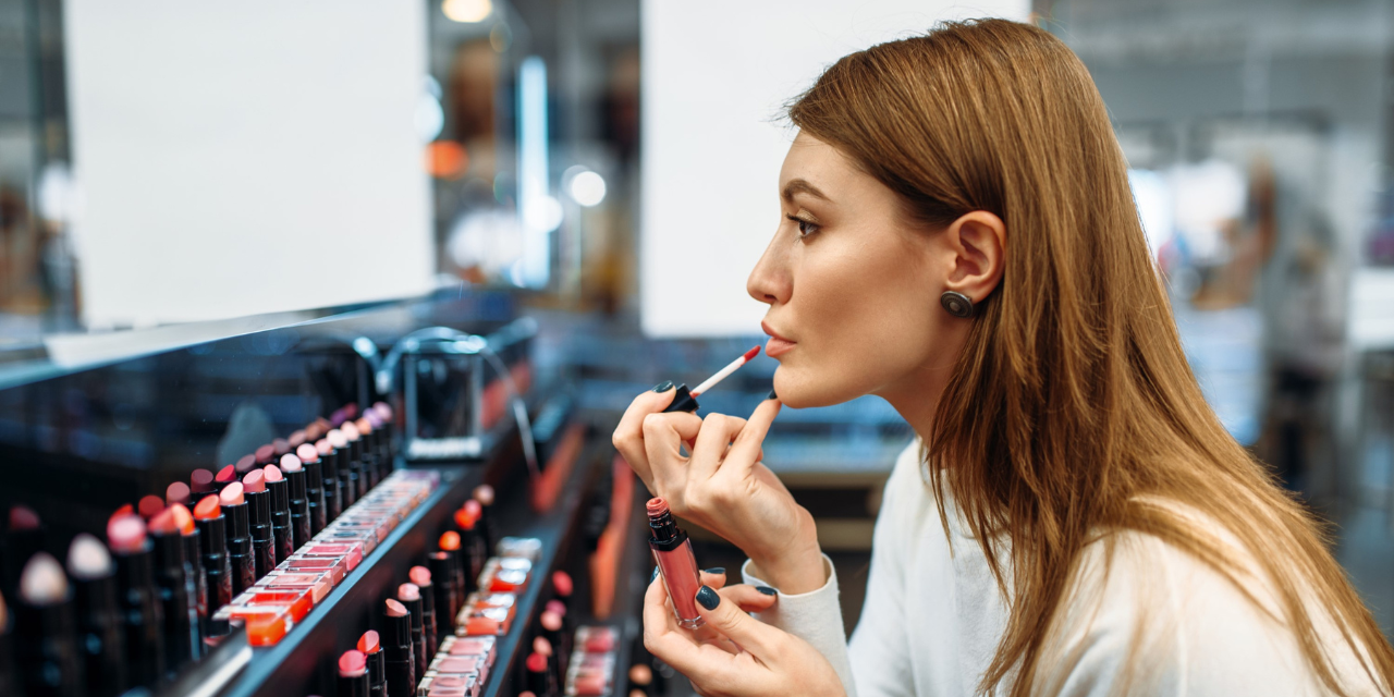 Woman applying lip color in a mirror